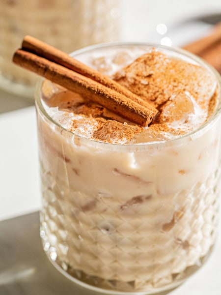 a white russian drunk with cinnamon sticks and cinnamon powder garnish on top