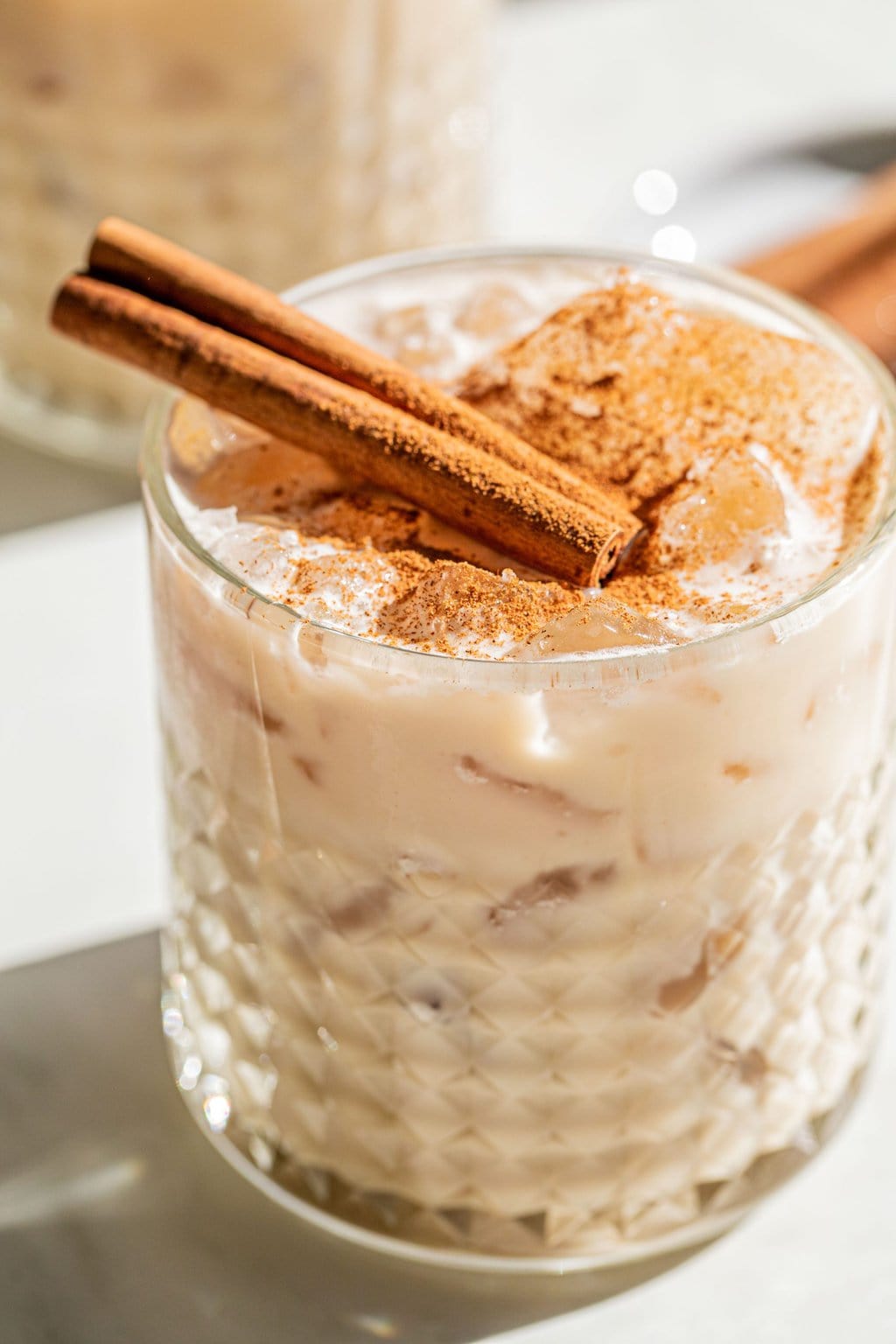 a white russian drunk with cinnamon sticks and cinnamon powder garnish on top