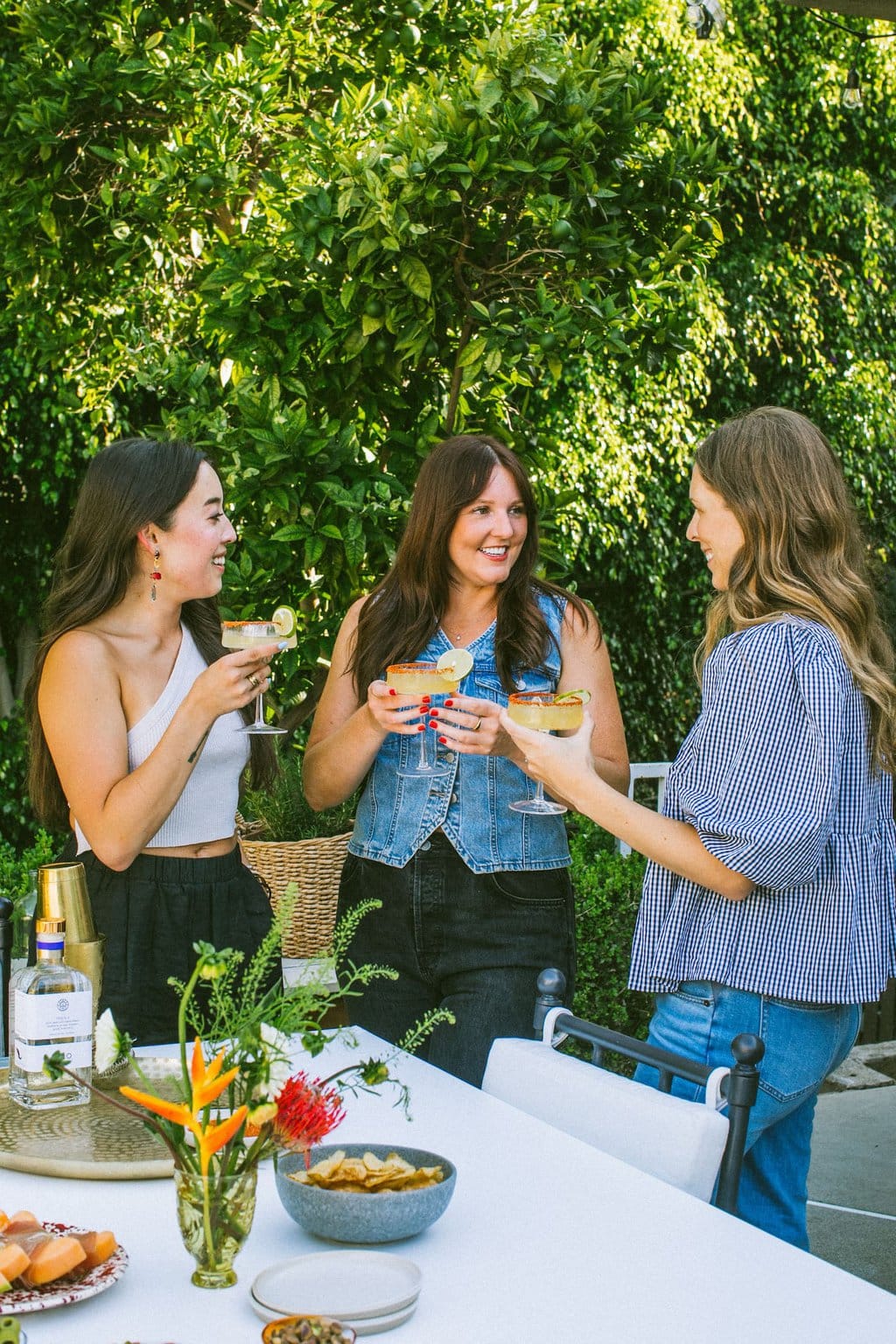 Elizabeth and friends standing outside talking and drinking.