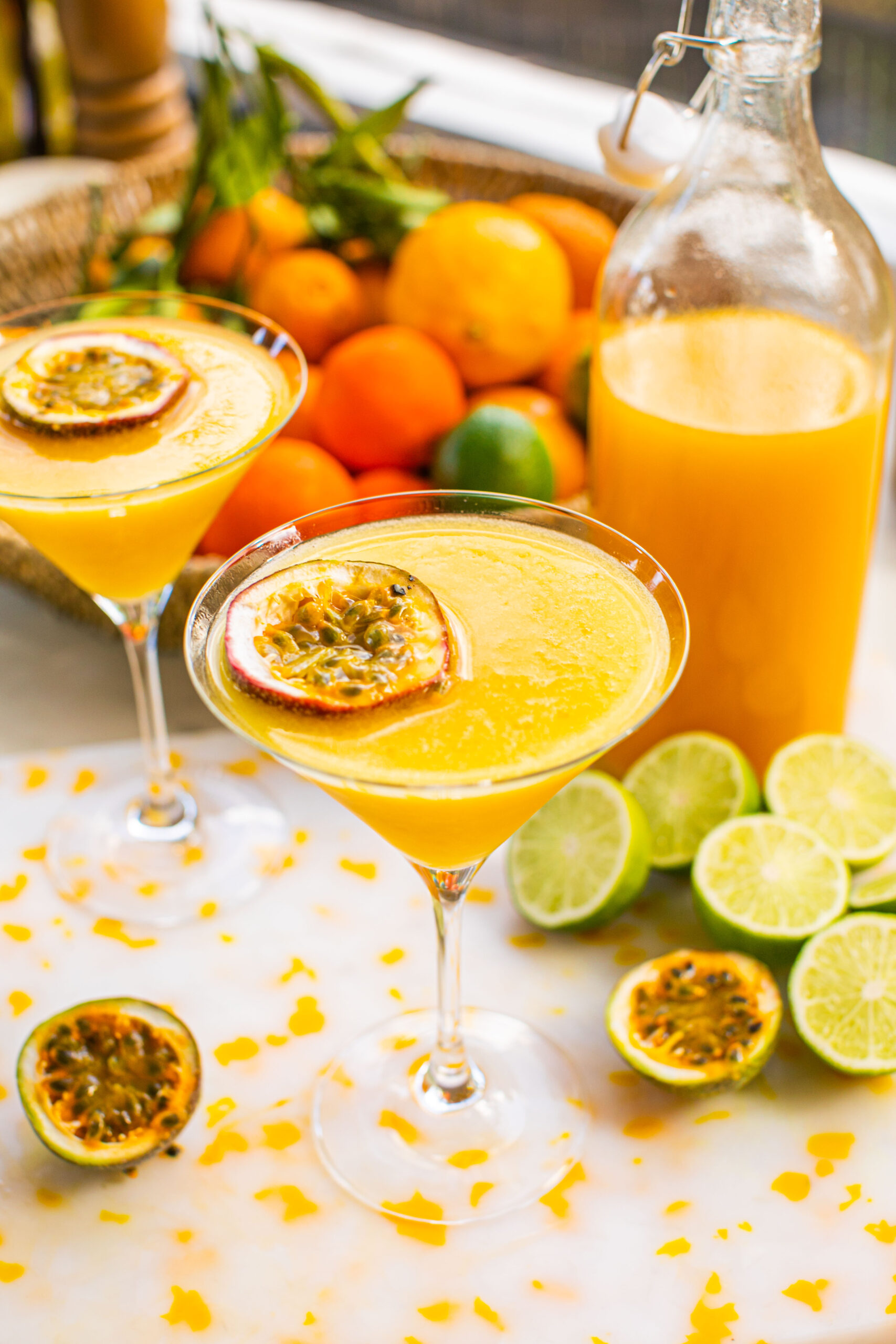 two martini glasses of passion fruit martini with passion fruit slices as garnish