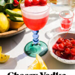 a cherry vodka sour with three cherries as garnish and text overlay