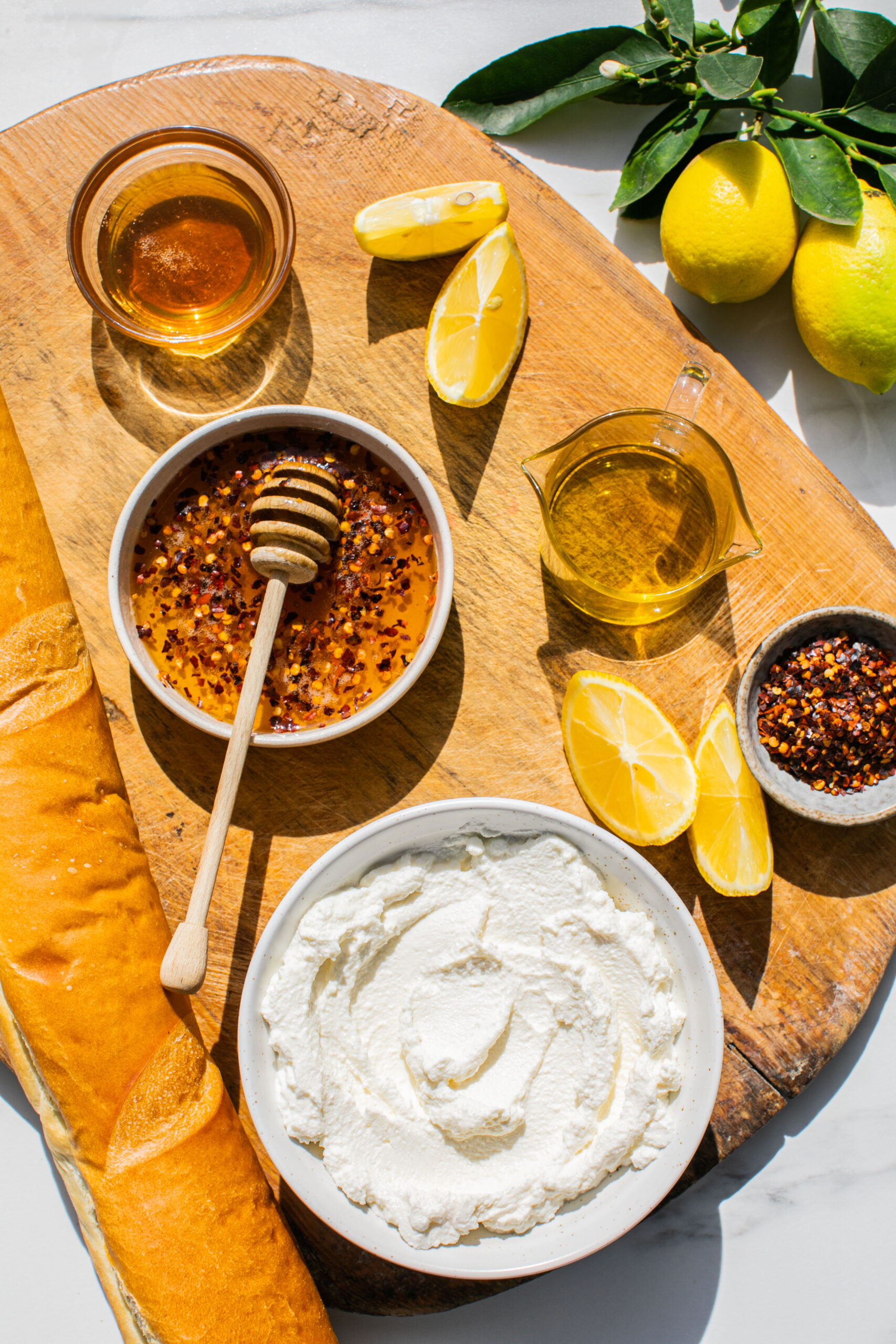 hot honey mixed with red pepper flakes, whipped ricotta, honey, lemon slices and bread