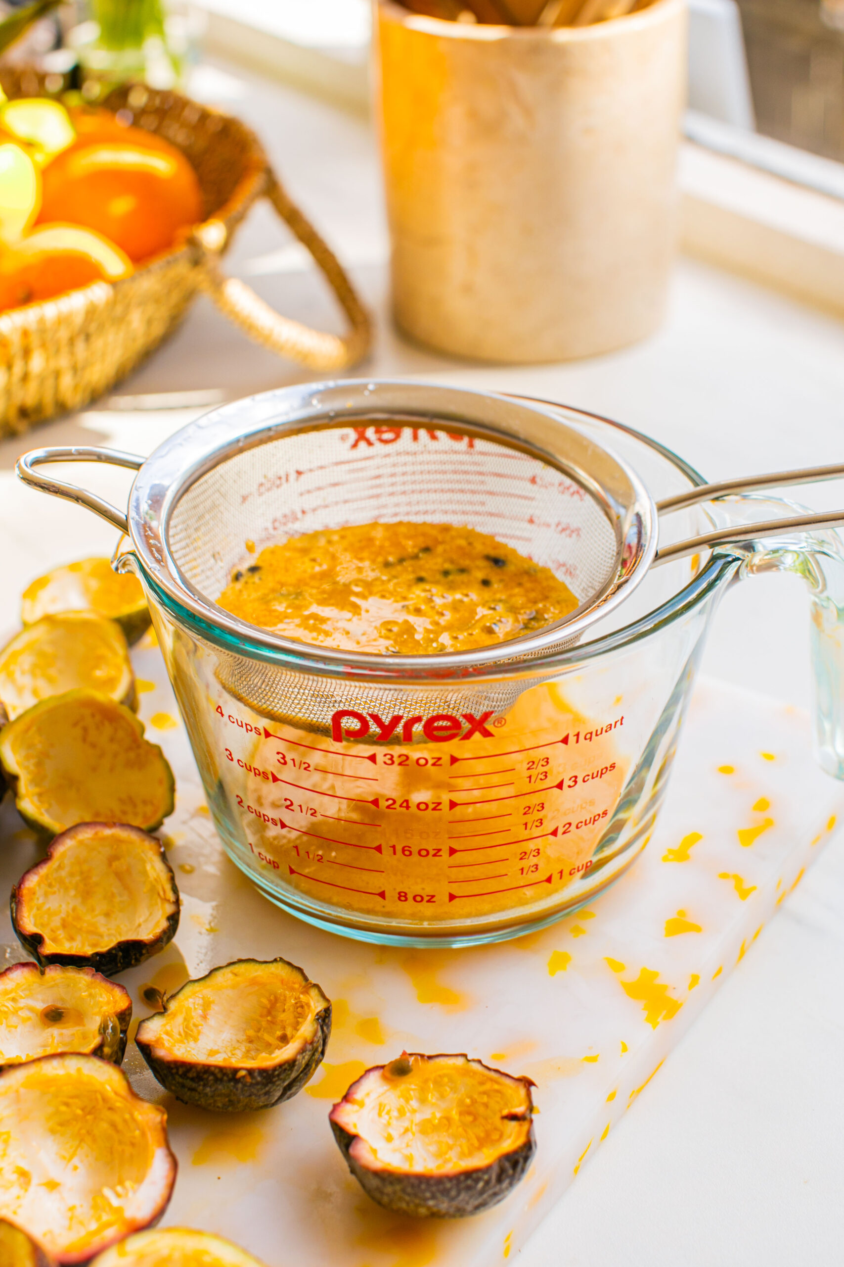 straining passion fruit puree into a pyrex