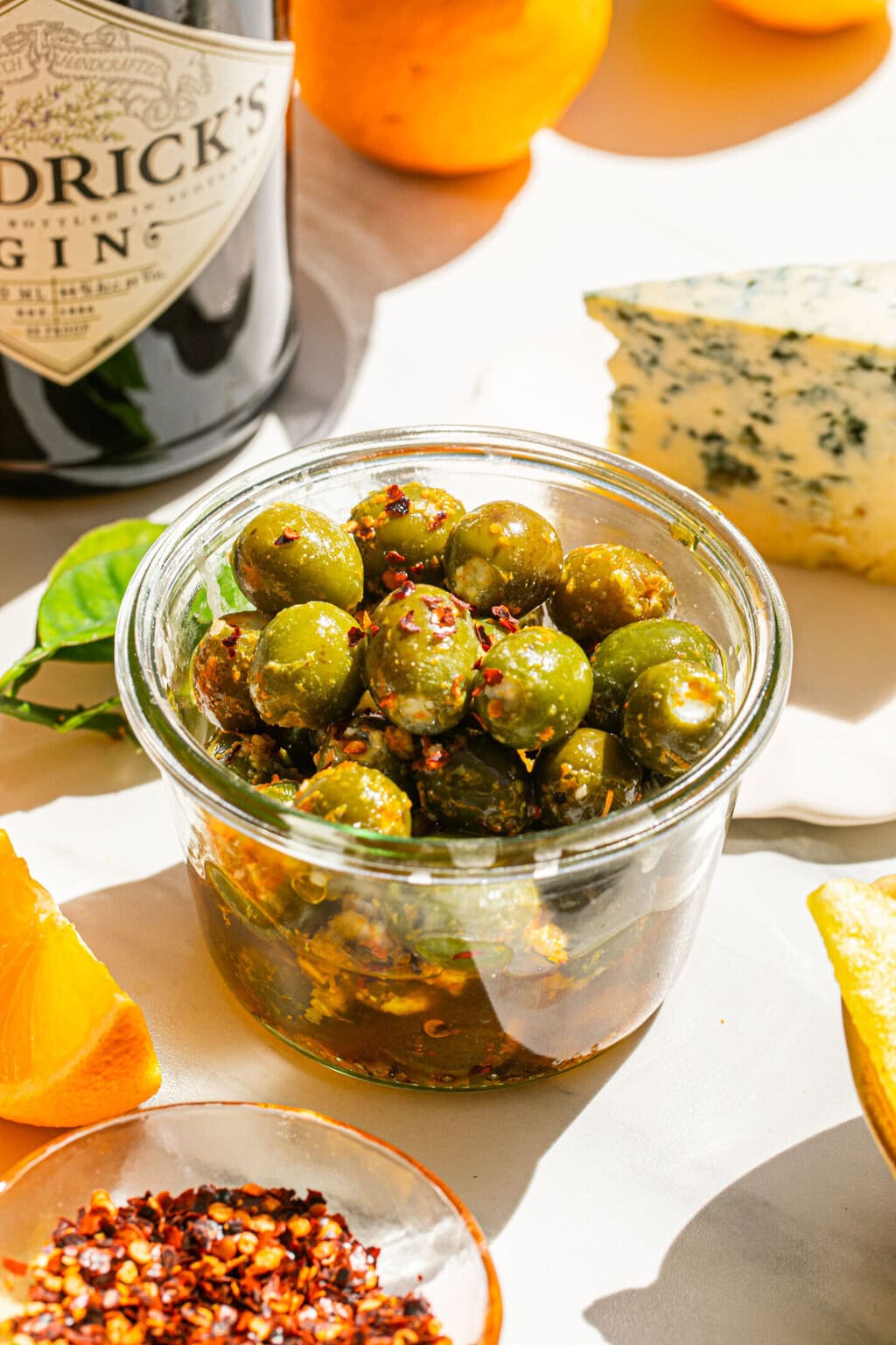 a small clear bowl full of marinated stuffed olives