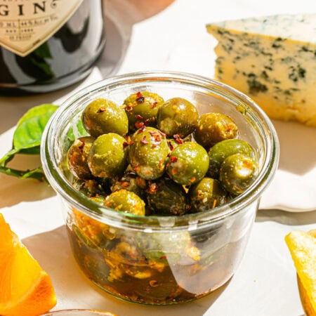 a small clear bowl full of marinated stuffed olives