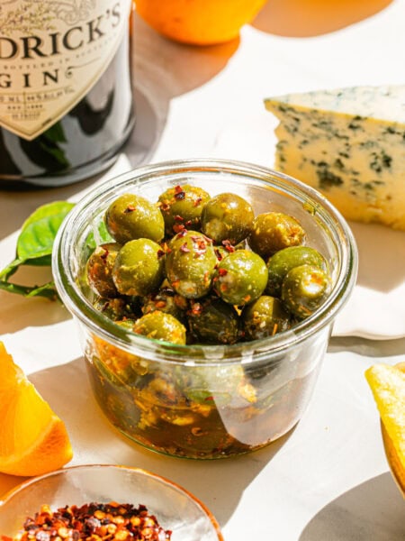 a small clear bowl full of marinated stuffed olives