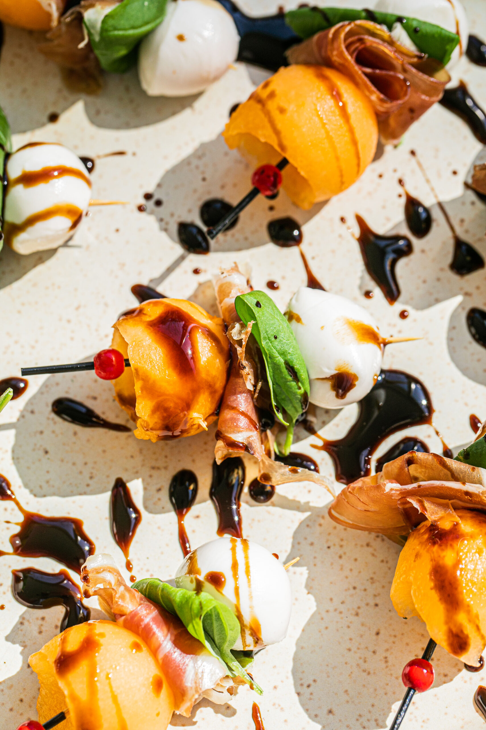 up close photo of melon skewers with prosciutto, mozzarella, and basil