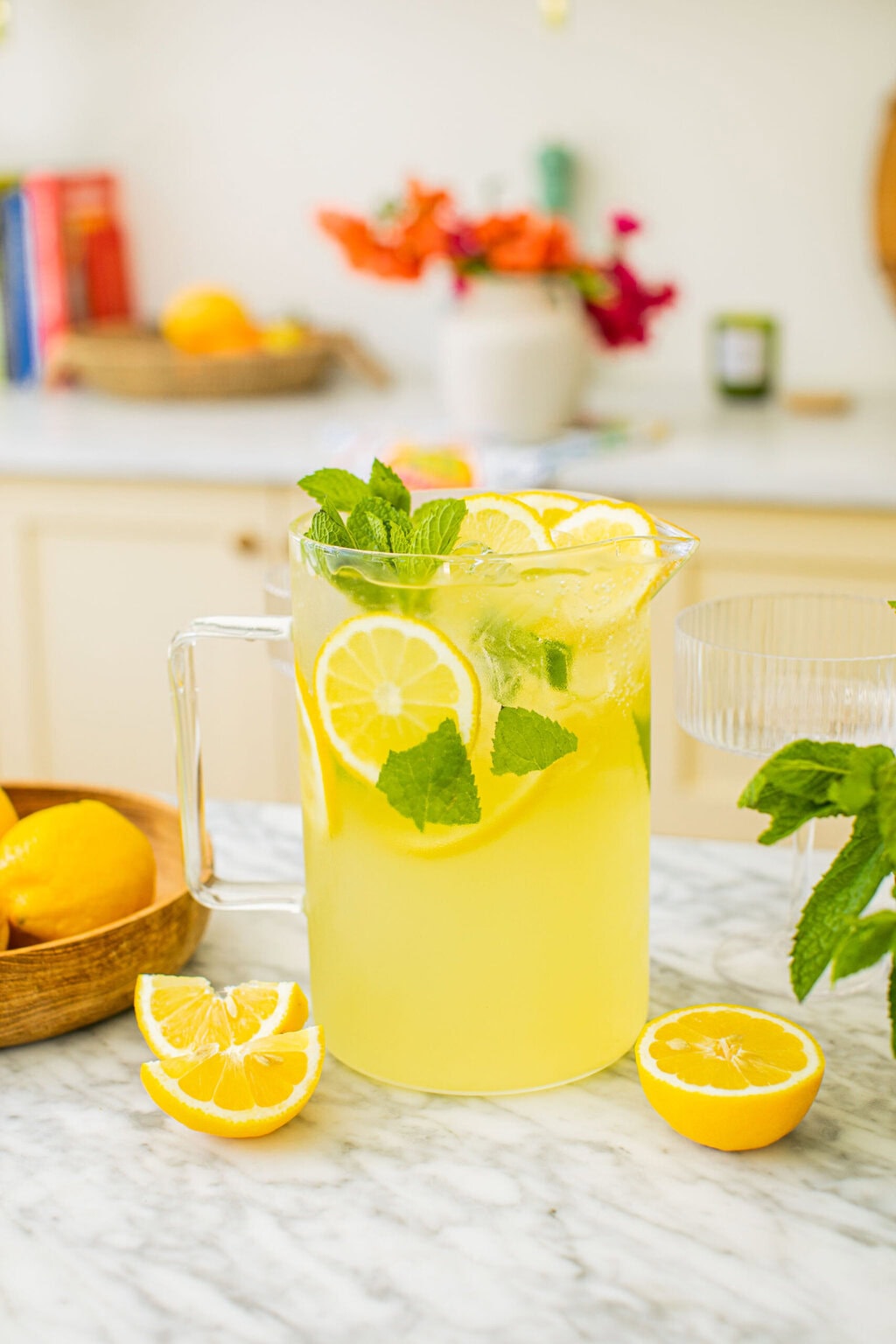 a pitcher of limoncello spritz with lemon slices around it on the counter