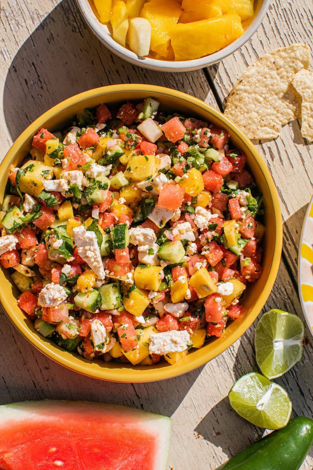 a large bowl of watermelon feta salad with feta, cucumber, and mango