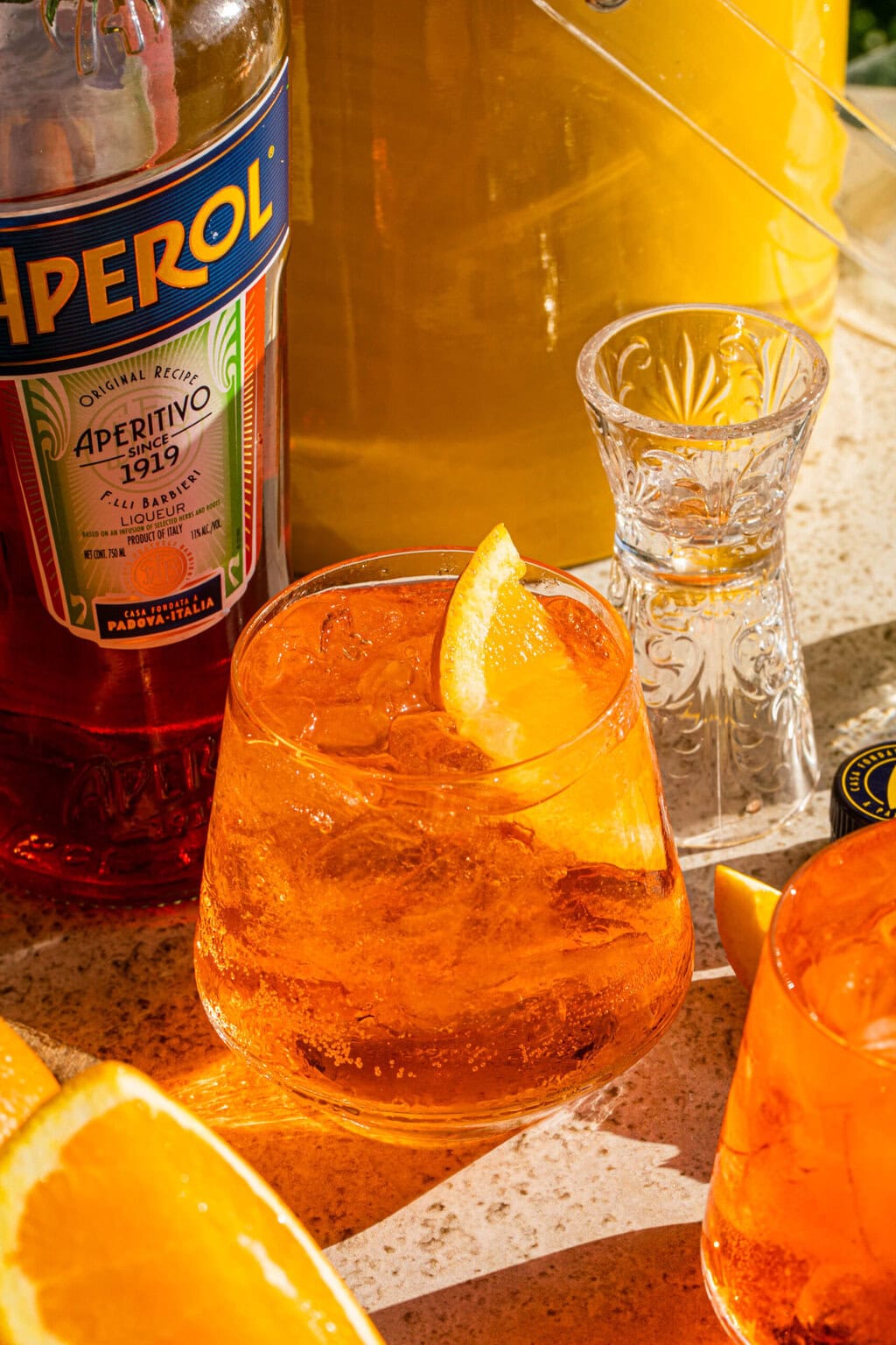 a glass full of aperol soda garnished with an orange wedge