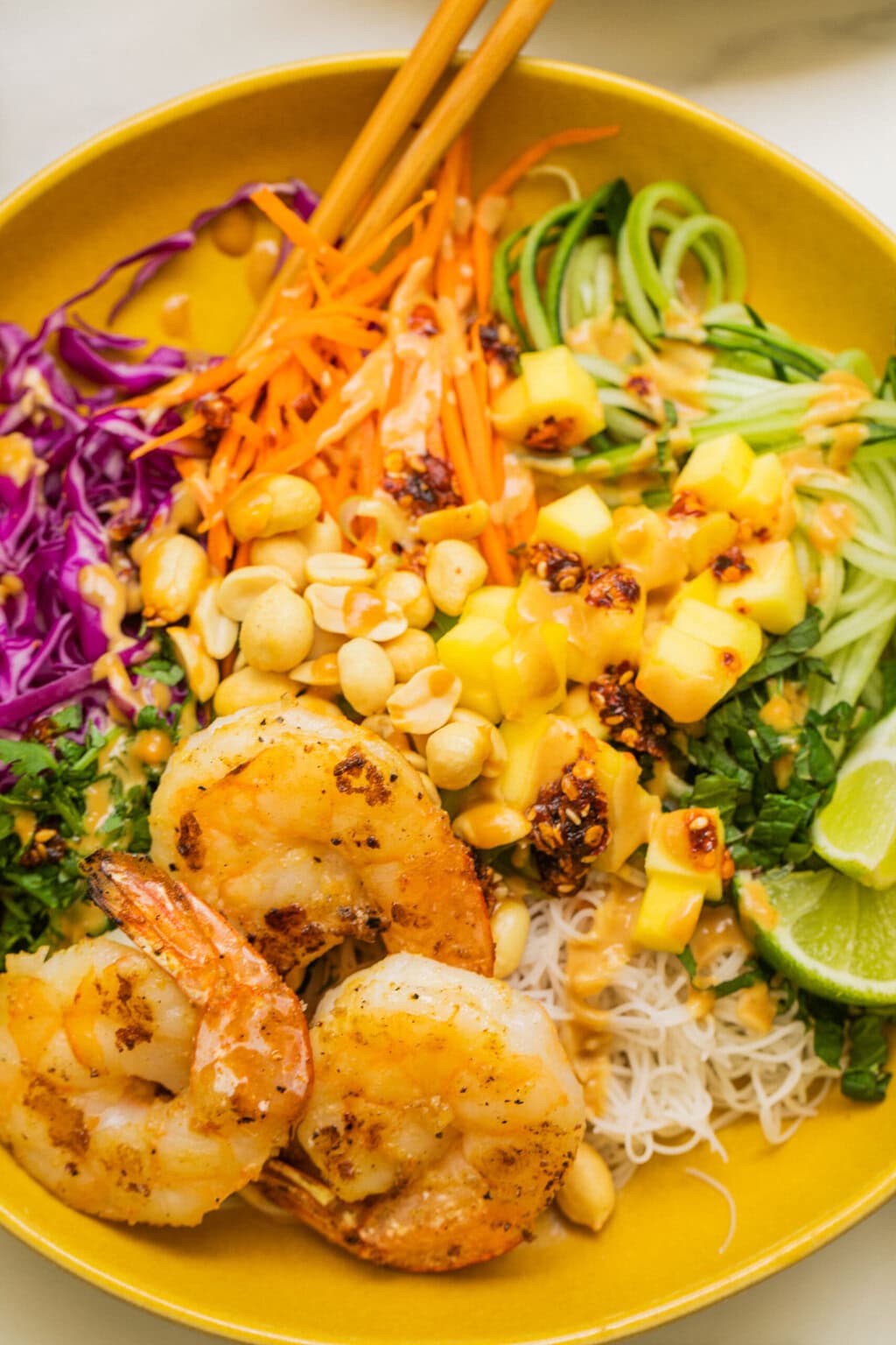 close up shot of the spring roll bowl with peanut sauce on top and shrimp