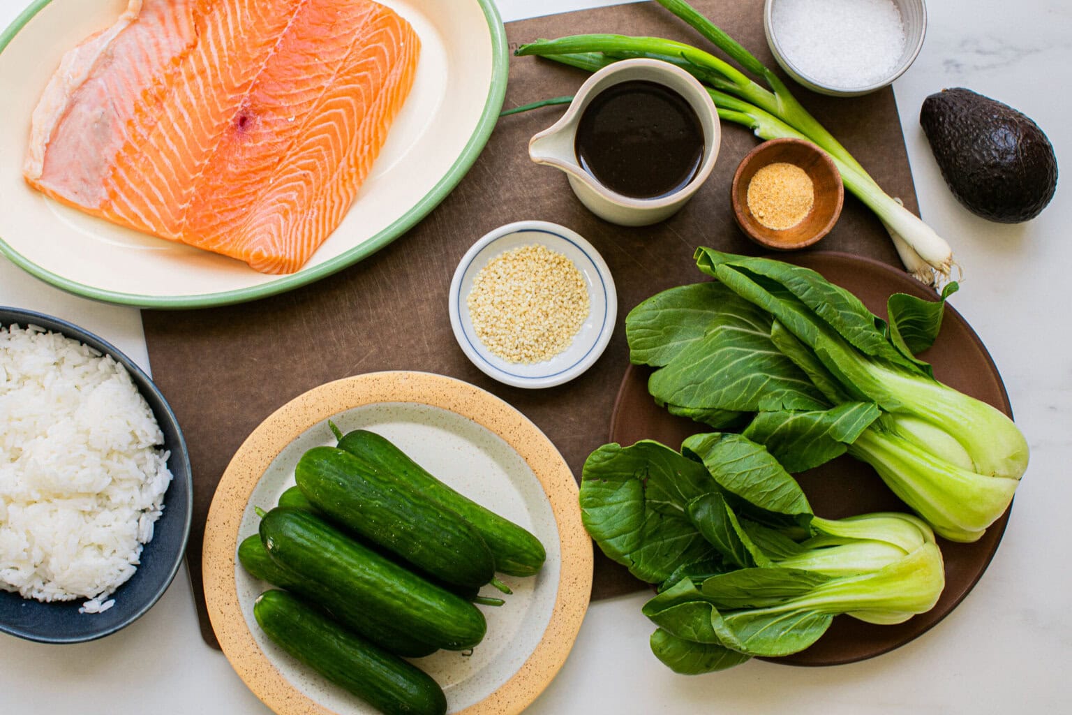 baby bok choy, salmon, marinade ingredients, sesame seeds, avocado, cucumber, green onion, and white rice