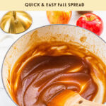 a white dutch oven filled with a batch of homemade apple butter