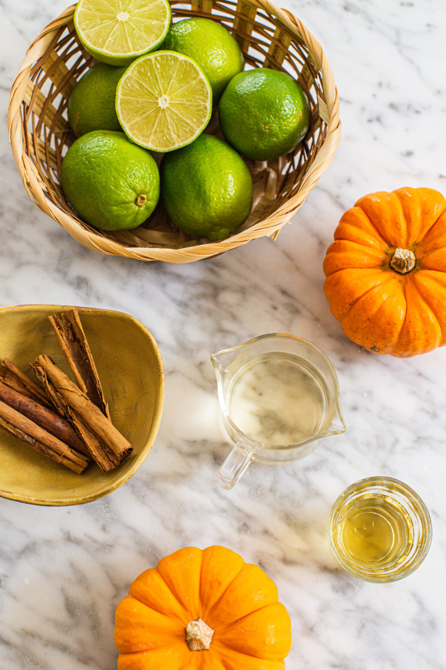 bowl of limes, tequila, cinnamon sticks, cointreau and some small pumpkins