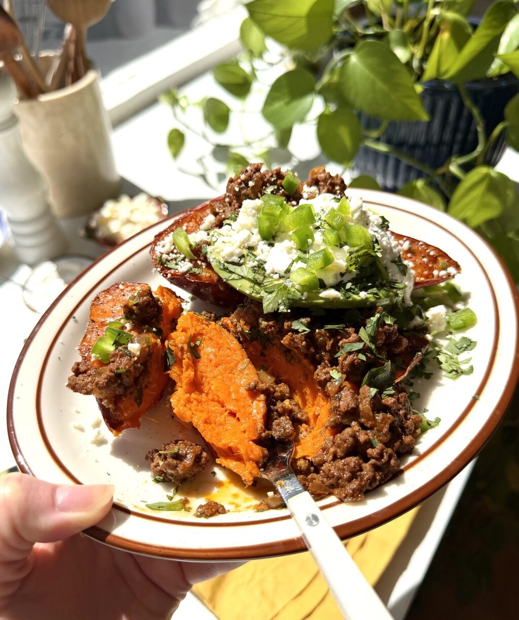 a plate of sweet potato being eaten with a white fork