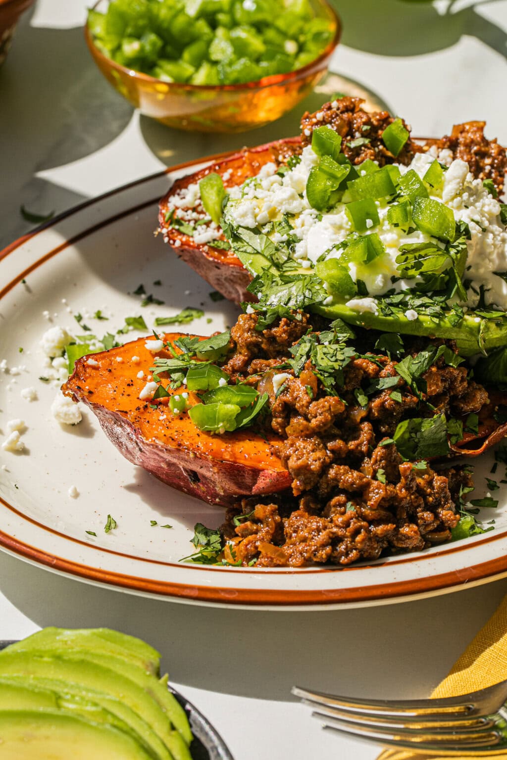 bowl of jalapenos, sweet potato and ground beef on a plate with brown lines, yellow napkin