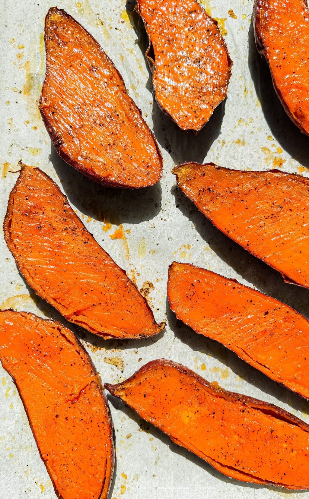 roasted sweet potato halves on a sheet pan with parchment paper