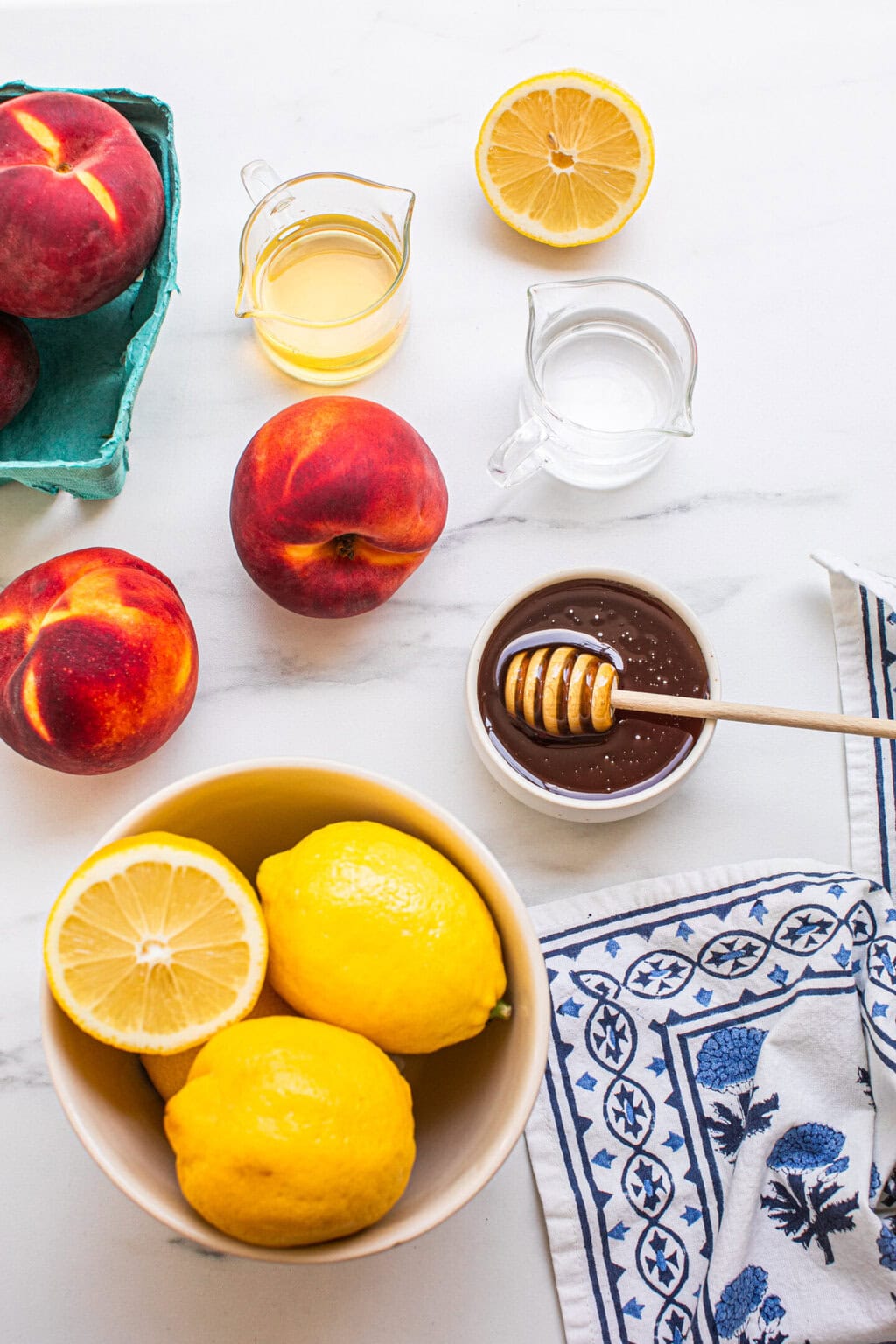 whole peaches, a bowl of lemons, triple sec, vodka, and a small bowl of honey